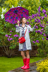 Image showing Beautiful woman with an umbrella in red rubber boots