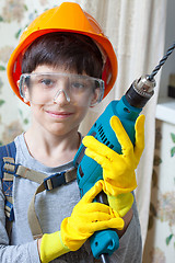 Image showing boy builder in goggles and with a drill