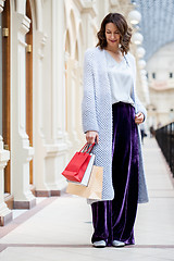 Image showing woman in a fashionable knitted coat with shopping bags