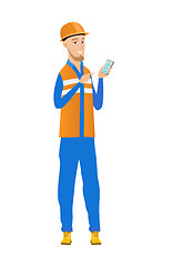 Image showing Young caucasian builder holding a mobile phone.