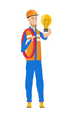 Image showing Young caucasian electrician holding lightbulb.