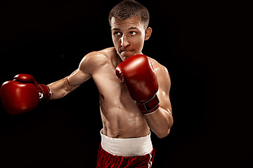 Image showing Male boxer boxing with dramatic edgy lighting in a dark studio