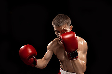 Image showing Male boxer boxing with dramatic edgy lighting in a dark studio