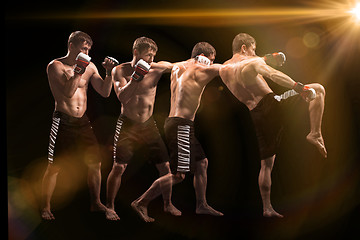 Image showing Male boxer boxing in punching bag with dramatic edgy lighting in a dark studio