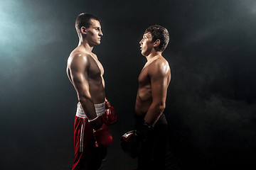 Image showing Two professional boxer standing on black smoky background,