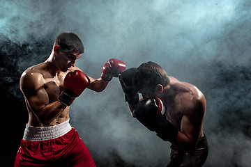 Image showing Two professional boxer boxing on black smoky background,