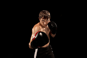 Image showing Male boxer boxing in punching bag with dramatic edgy lighting in a dark studio