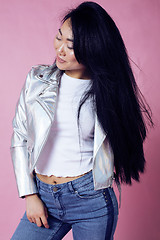 Image showing young pretty smiling asian korean girl wearing modern fashion clothers on pink background, lifestyle people concept
