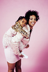 Image showing young pretty african-american mother with little cute daughter hugging, happy smiling on pink background, lifestyle modern people concept 