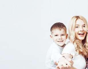 Image showing young modern blond curly mother with cute son together happy smiling family posing cheerful on white background, lifestyle people concept, sister and brother friends 