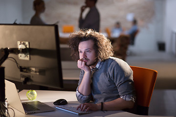 Image showing man working on computer in dark office