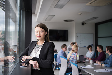 Image showing Elegant Woman Using Mobile Phone by window in office building