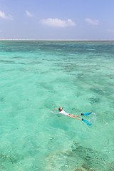 Image showing Woman snorkeling in clear shallow sea of tropical lagoon with turquoise blue water.