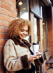 Image showing young pretty african american women drinking coffee outside in c