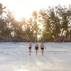 Image showing Group of Senior Friends Enjoying Beautiful Sunset Walk on the Beach.