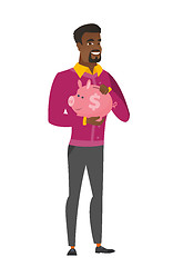 Image showing African-american business man holding piggy bank.