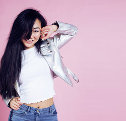 Image showing young pretty smiling asian korean girl wearing modern fashion clothers on pink background, lifestyle people concept 