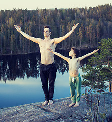 Image showing middle age man with little cute son doing sport yoga on the top of the mountain together, happy family lifestyle people outdoor, summer wild nature for training 