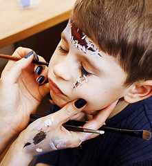 Image showing little cute child making facepaint on birthday party, zombie Apo