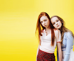 Image showing lifestyle people concept: two pretty young school teenage girls having fun happy smiling on yellow background 