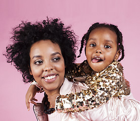 Image showing young pretty african-american mother with little cute daughter hugging, happy smiling on pink background, lifestyle modern people concept 