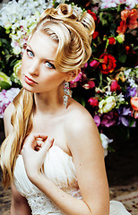 Image showing beauty young blond woman bride alone in luxury vintage interior with a lot of flowers 