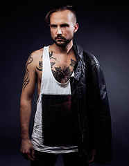 Image showing A man with tattooes on his arms. Silhouette of muscular body. caucasian brutal hipster guy with modern haircut, looking like criminal