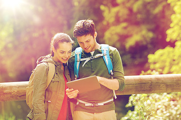 Image showing happy couple with backpacks and tablet pc outdoors