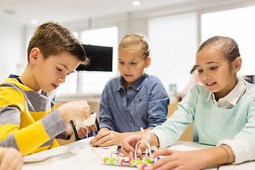 Image showing happy children building robots at robotics school