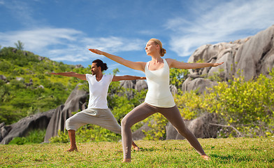 Image showing couple making yoga in warrior pose at seaside