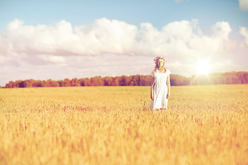 Image showing happy young woman in flower wreath on cereal field