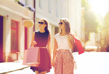 Image showing happy women with shopping bags walking in city 