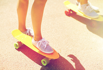 Image showing close up of female feet riding short skateboard