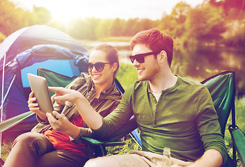 Image showing happy couple with tablet pc at camping tent