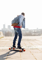 Image showing happy young man or teenage boy riding on longboard