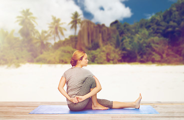 Image showing woman doing yoga in twist pose on beach