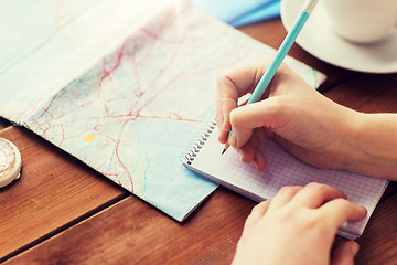 Image showing close up of traveler hands with notepad and pencil