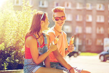 Image showing happy teenage couple eating hot dogs in city