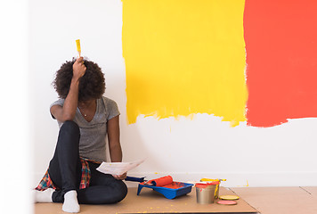 Image showing back female painter sitting on floor