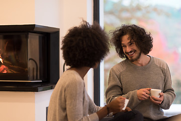 Image showing multiethnic couple  in front of fireplace