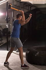 Image showing man workout with hammer and tractor tire