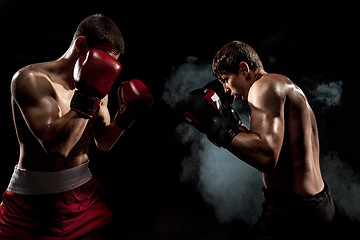 Image showing Two professional boxer boxing on black smoky background,