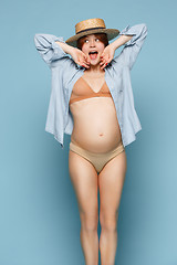 Image showing Young beautiful pregnant woman standing on blue background