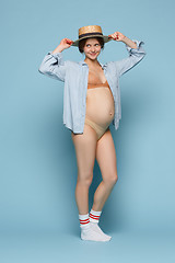 Image showing Young beautiful pregnant woman standing on blue background