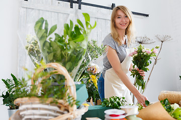 Image showing Smiling blonde in flower shop