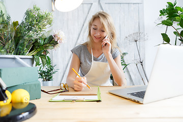 Image showing Young florist talking on phone