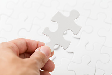 Image showing Hand holding puzzle piece