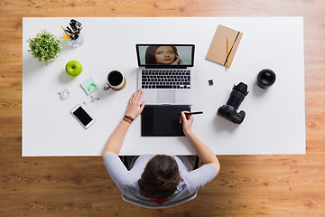 Image showing woman with camera working on laptop at table