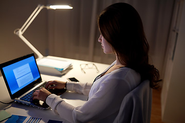 Image showing businesswoman with laptop at night office