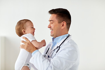 Image showing happy doctor or pediatrician with baby at clinic